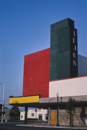 Neon Theater Facade, architecture, modern building, minimalism, color blocking, urban photography, theater, red wall, blue sky, geometric, mid century, city